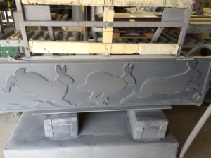 This shows the rabbit image once it is blasted.It is still clamped to the cart that holds it steady in the sandblasting room. 