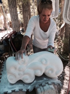 Julie is working on perfecting a beautiful swirling sculpture with smooth and textures surfaces. About one by one by two feet. 